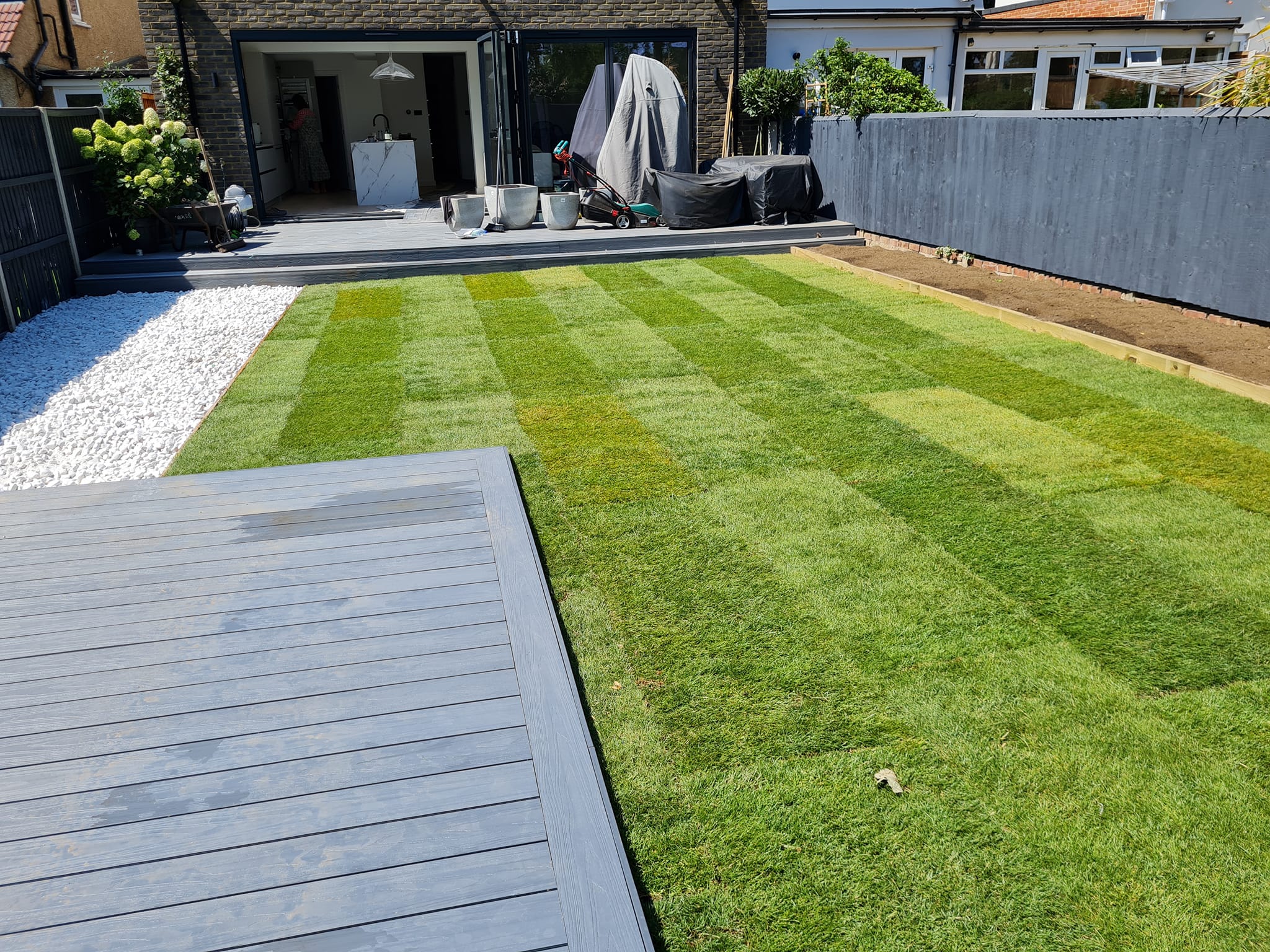 Freshly laid striped lawn viewed from decking area
